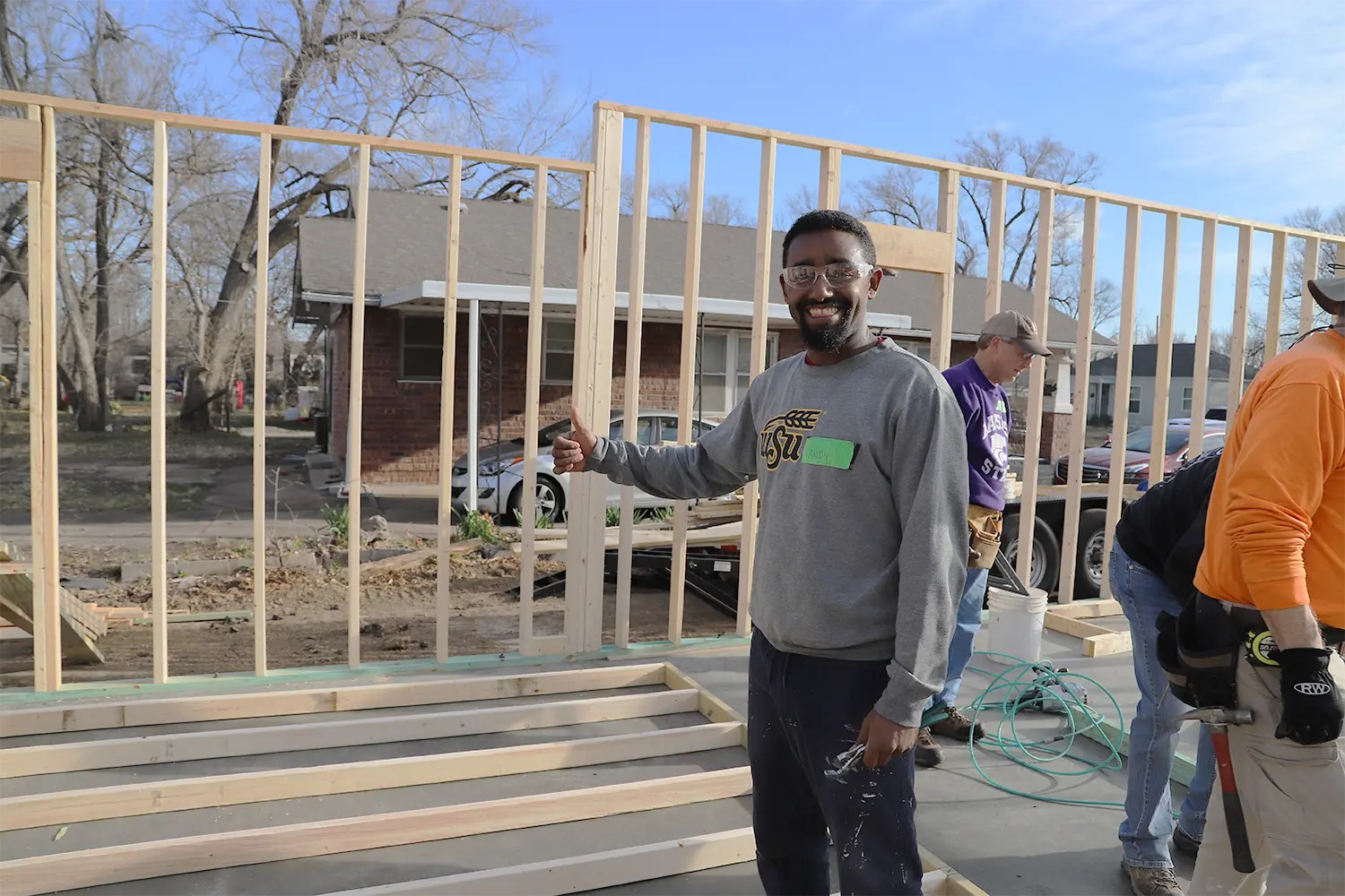 Andy is standing with volunteers at a wall-raising event.