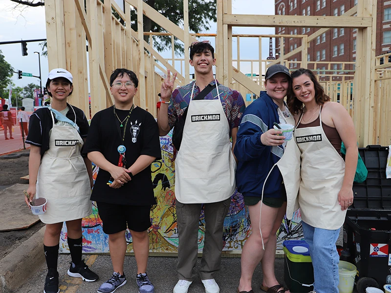 Participants standing in front of the framed house.