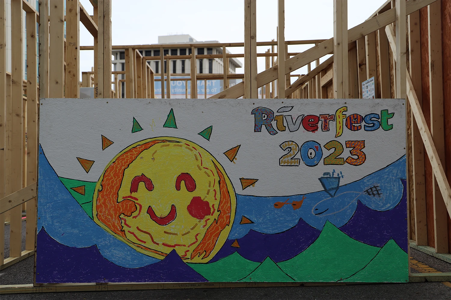 A Riverfest 2023 banner against the side of a framed home.