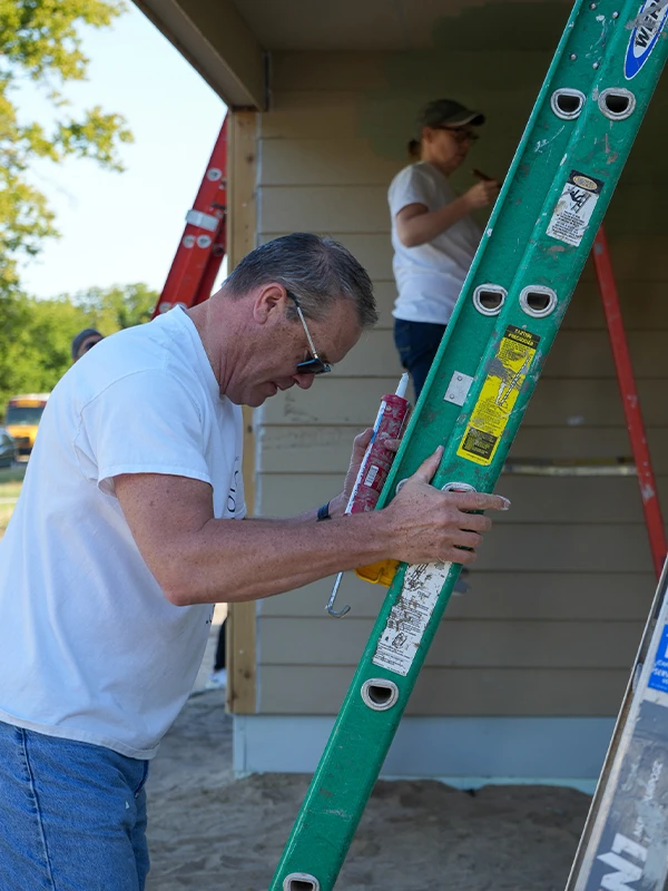 Bank of America employee adjusts ladder.