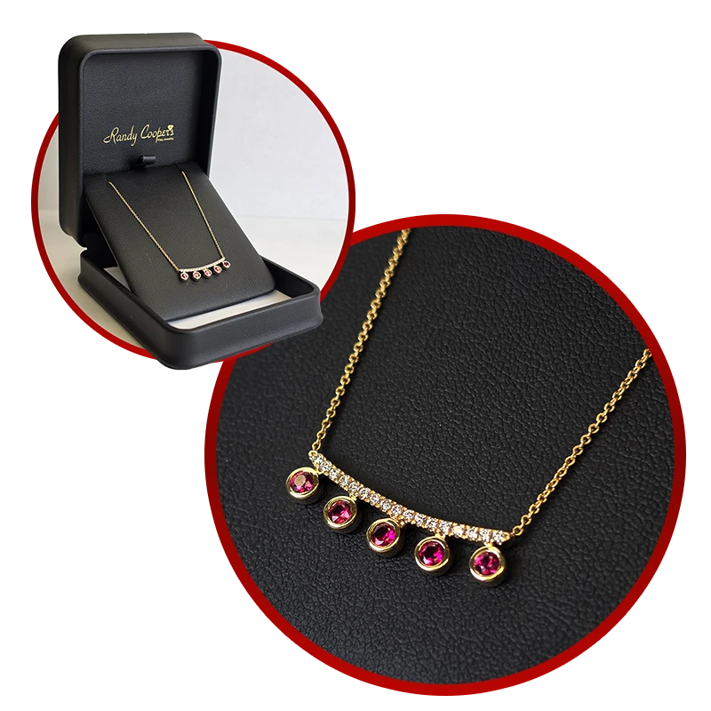 A close view and a whole-case view of a yellow gold ruby and diamond necklace.