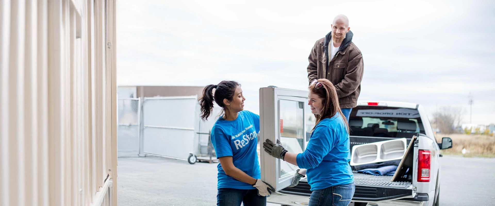 ReStore volunteers loading a window off a truck.