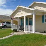 Street view of a single-story Habitat for Humanity home with a front porch and driveway.