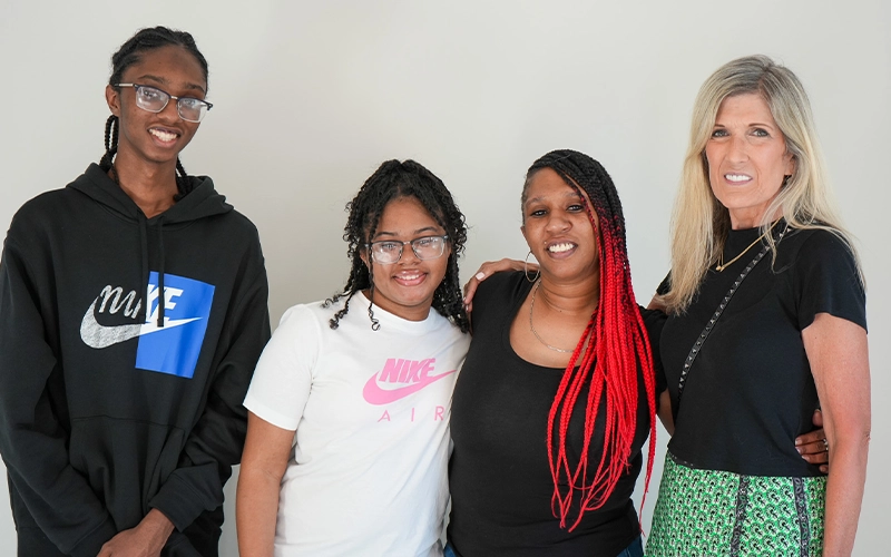 A family smiling with sponsors.