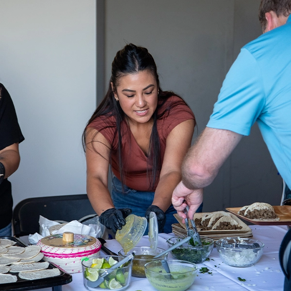 A Habitat family member serving food.