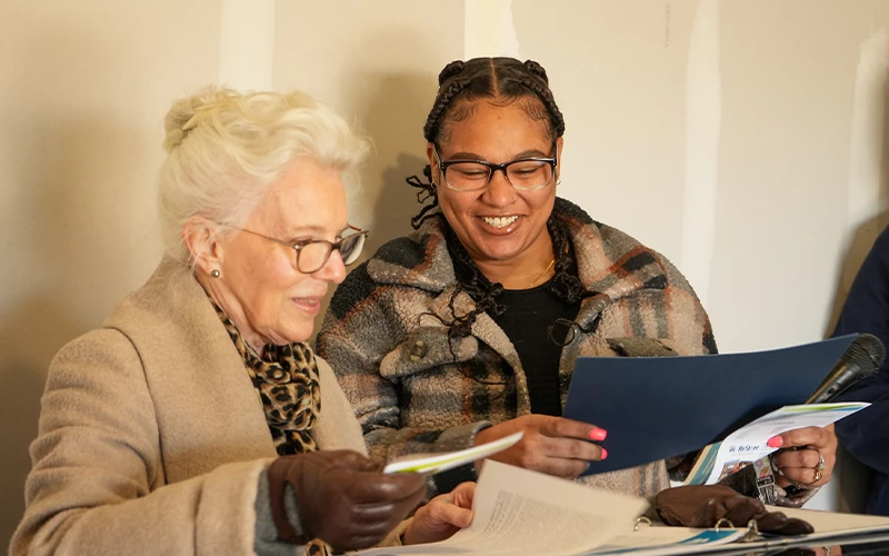 A budget coach handing a certificate to a family partner.