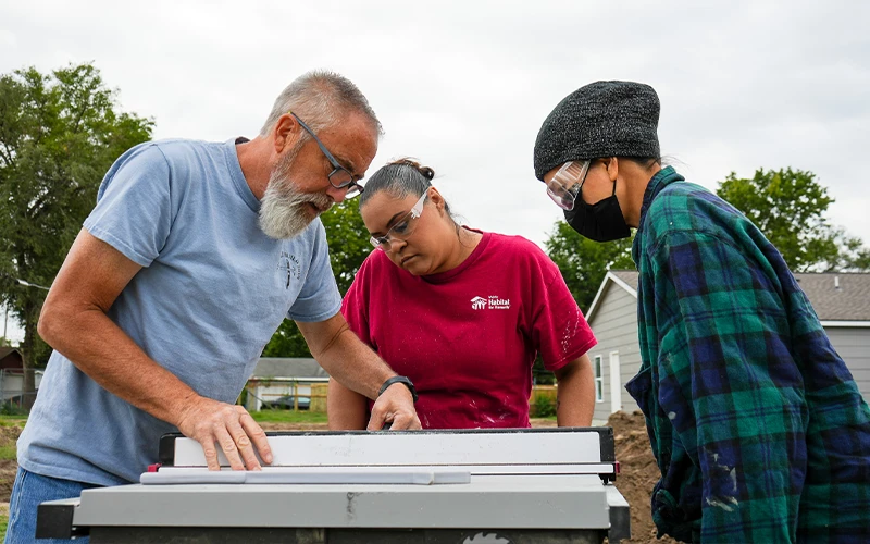Volunteers getting instructions from a Habitat construction worker.